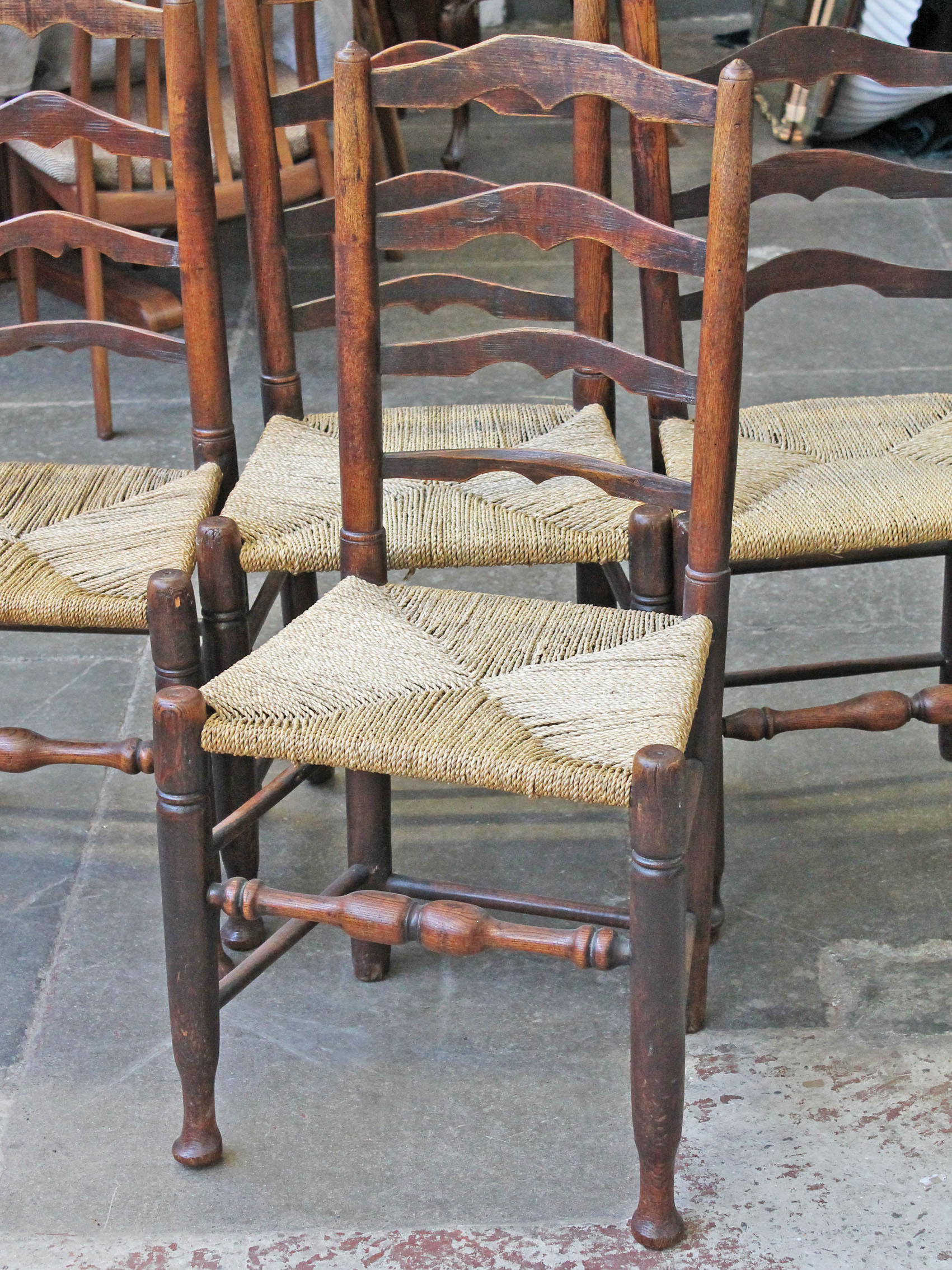 A matched set of four Lancashire ash ladder back rush seated chairs.