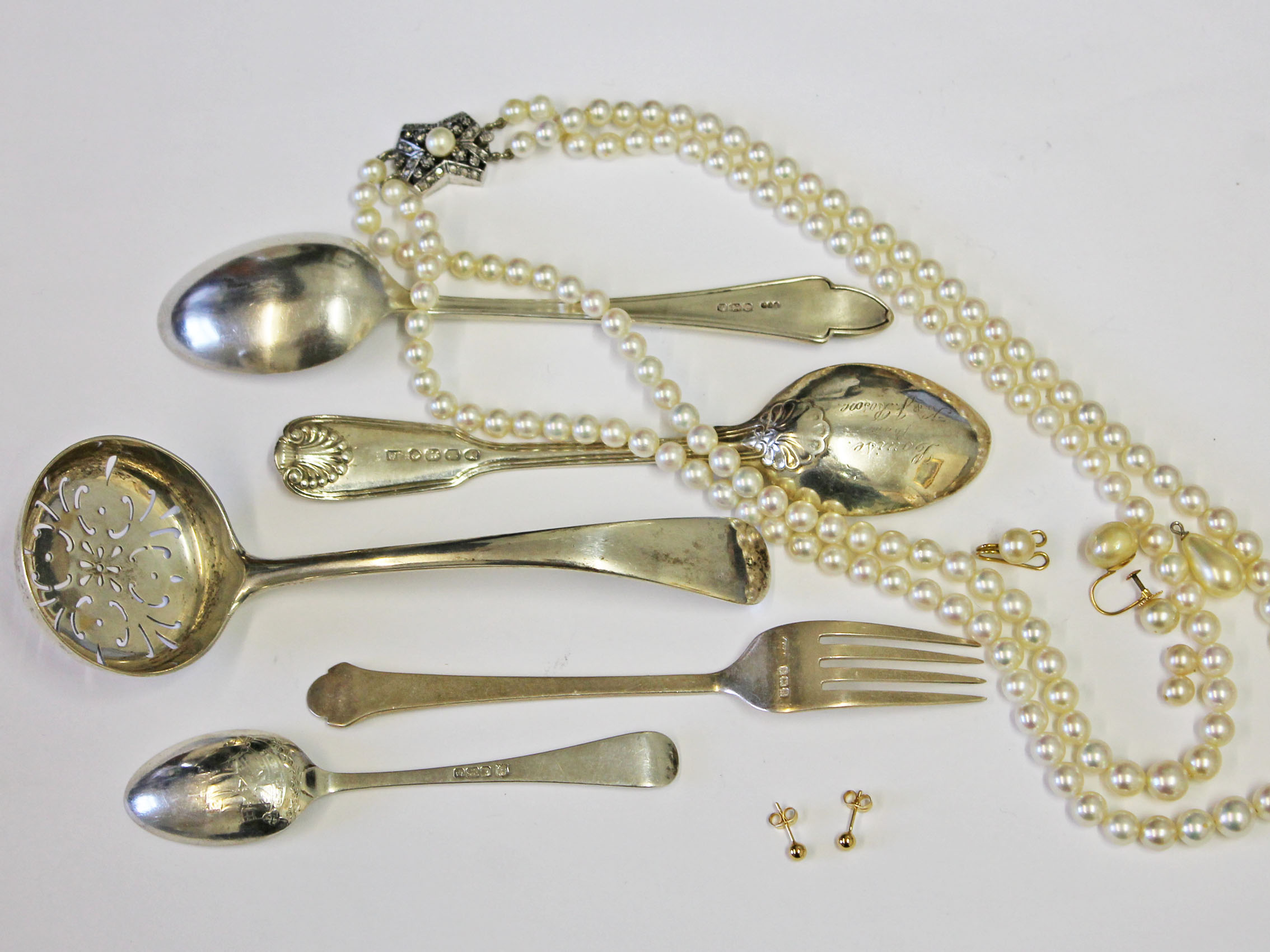 A mixed lot comprising various hallmarked silver cutlery, a pair of stud earrings marked '750' wt.