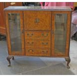 A 1950s burr walnut display cabinet in the manner of Epstein. W128cm D34cm H117cm.