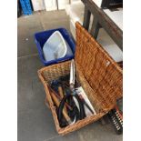 A WICKER BASKET WITH GARDEN TOOLS