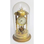 A brass revolving pendulum mantel clock under glass dome. H43cm.