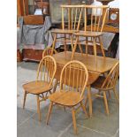 An Ercol light elm and beech drop leaf table and six chairs.