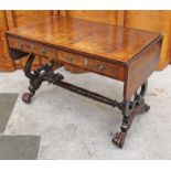 A Regency period rosewood and satin wood crossbanded sofa table having turned stretcher, lyre ends