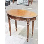 A Waring & Gillow Edwardian oval mahogany occasional table with fluted legs. L91cm D32cm H72cm.