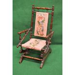 Child's American style rocking chair the frame and arms being comprised of turned spindles and