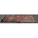 Rust ground rug with red, blue and cream pattern - 96" x 41.