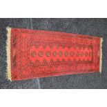 Small red ground carpet runner having cream and black pattern with end tassels - 57" x 21"