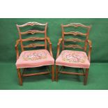 Two mahogany elbow chairs having pierced and carved top rails over three matching horizontal back