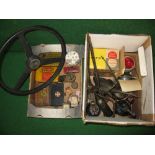Two boxes of automobilia to include a steering wheel, oil cans,