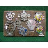 Eight motoring badges mounted onto a board to include early AA, AA Motorcycle, AA Commercial,