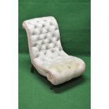 Victorian buttoned slipper chair having scrolled shape and standing on turned feet with castors