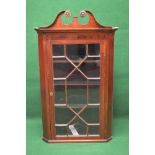 Mahogany wall hanging corner cabinet having scrolled top over a glazed door enclosing three fixed