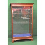 Mahogany floor standing display case having moulded cornice over glazed front and back with glazed
