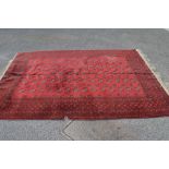 Red ground rug having black and cream pattern with end tassels - 121" x 82"