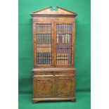 Walnut bookcase having two doors simulated as four shelves of leather bound books opening to reveal