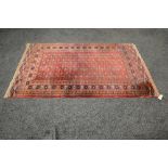 Red ground carpet having orange, blue and white pattern - 78" x 49.