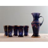 A blue glass jug and 5 matching beakers