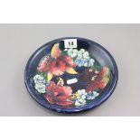 Moorcroft Pottery Plate, blue ground decorated with flower and impressed mark to base