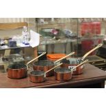 Set of five small copper & brass graduating saucepans