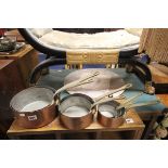 Set of seven graduating copper saucepans with brass handles