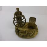 Brass figure of a blacksmith at work marked 'Reg Design' to bottom