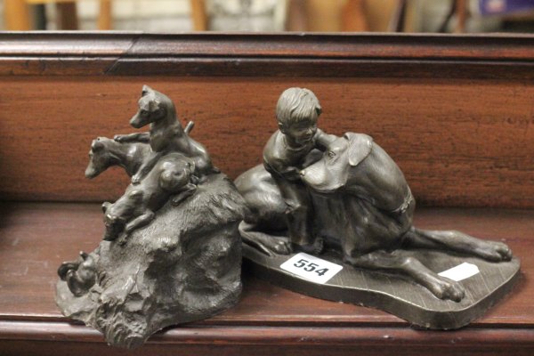 Bronzed figure of a boy and dog plus another similar of a group of Terriers