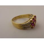 18ct Yellow Gold Ring set with a cluster of seven oval rubies and the shoulders set each side with