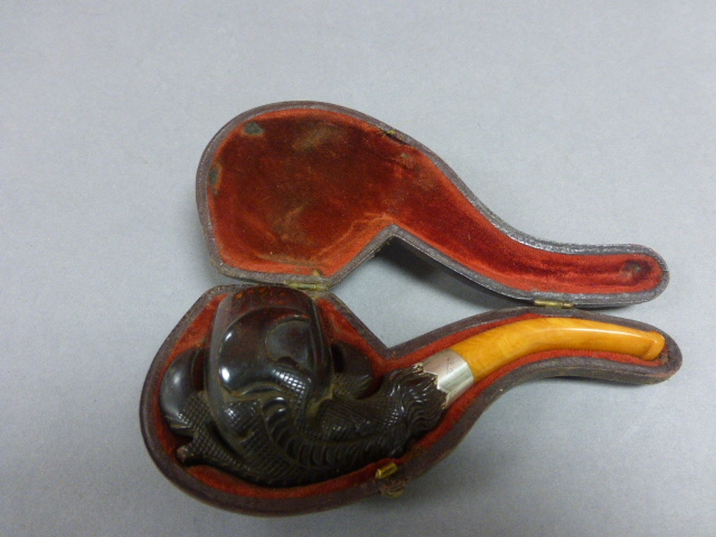 Cased Meerschaum Pipe with carved claw bowl, amber mouth piece and silver collar