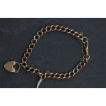 9ct Gold Curb Link Bracelet with clip to one end with attached 9ct Gold Heart Shaped Padlock