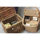 Two wicker picnic baskets containing a quantity of vintage tins and cigar boxes