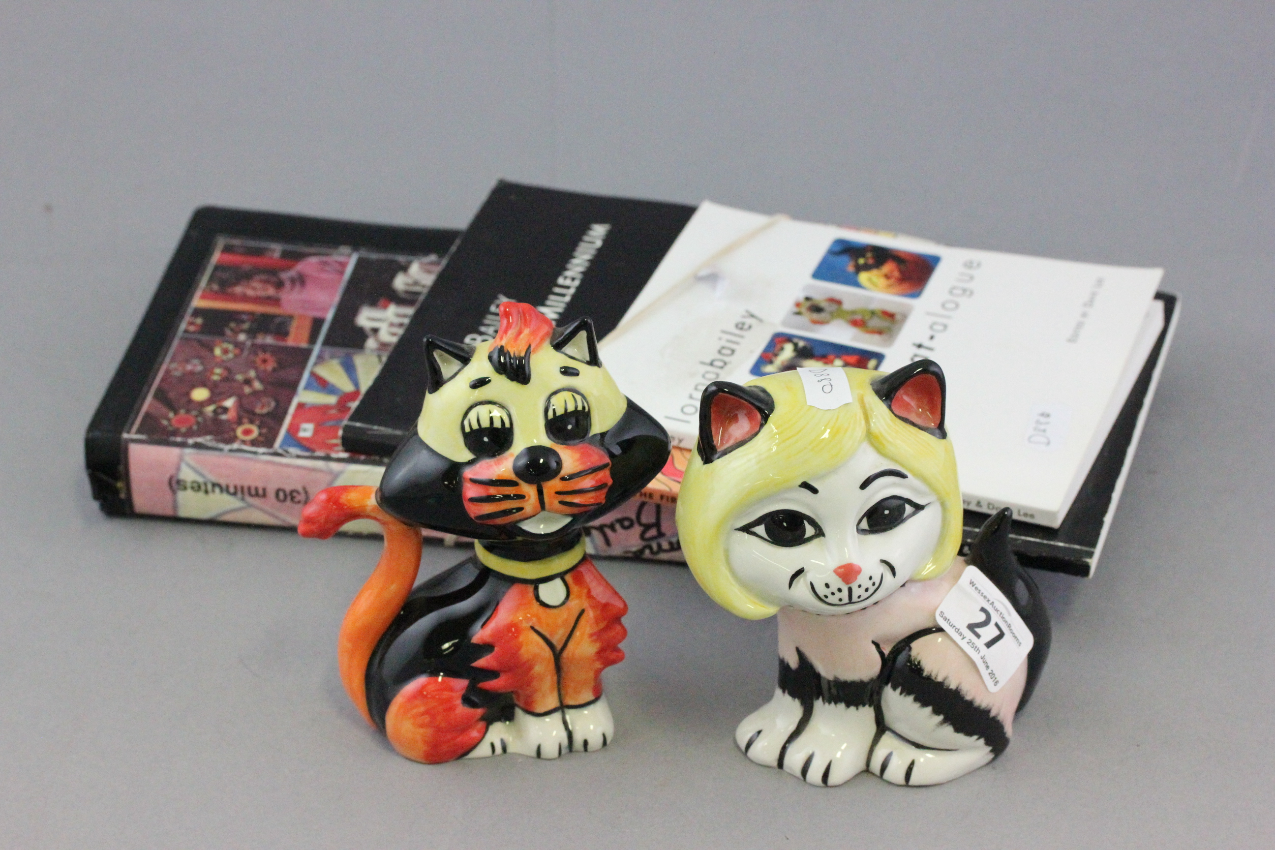 Two Lorna Bailey Cats, one marked CC and the other LL together with accompanying reference books