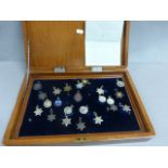 Various silver and enamel swimming and other sports badges encased in a mahogany box