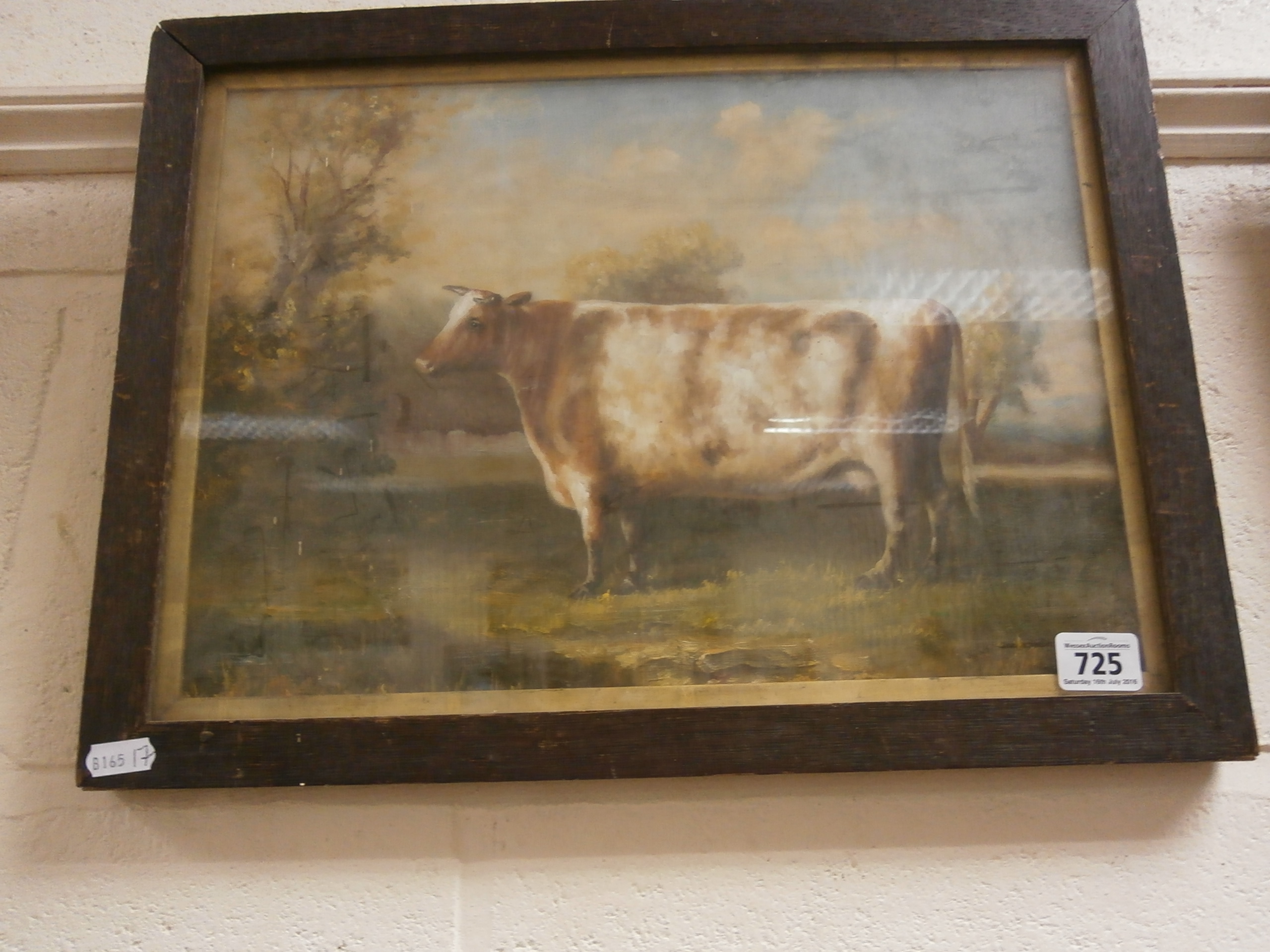 An oak framed oil painting of a bovine study of a cow in a pasture