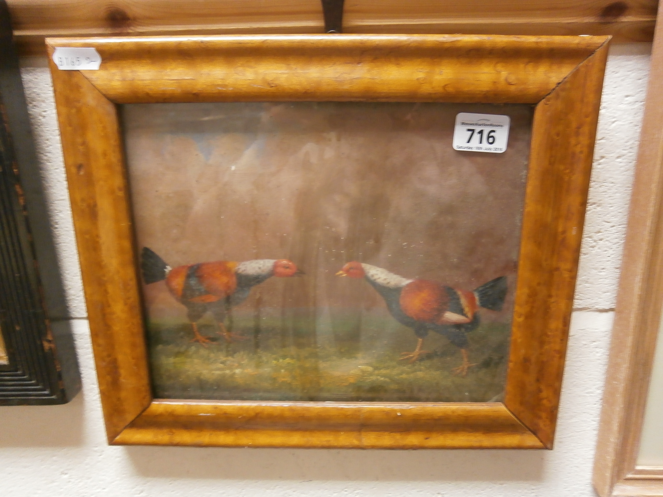 A maple framed oil painting of fighting cocks in a landscape