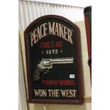 A painted wooden relief sign; Peacemaker Won The West; 1873 Colt 45 7.5 inch barrel