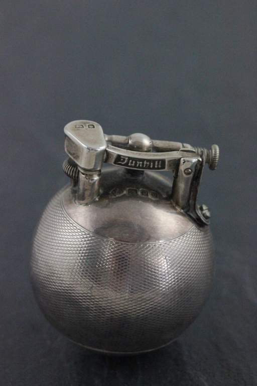 A hallmarked silver Dunhill lighter; of spherical form; with engine turned decoration; the hinged