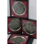 A set of four hallmarked silver Christmas plates; each embossed with a different party scenes;