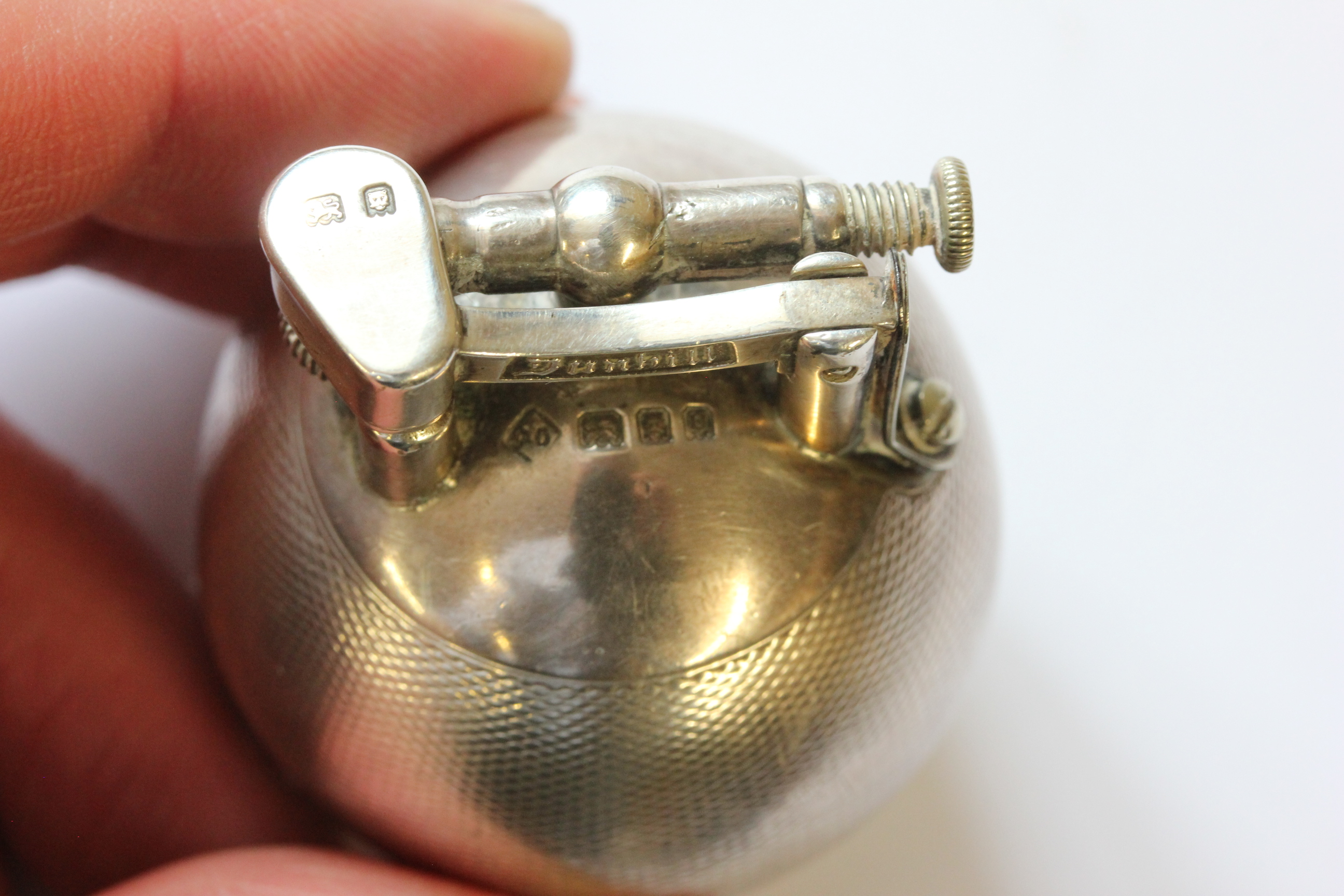 A hallmarked silver Dunhill lighter; of spherical form; with engine turned decoration; the hinged - Image 11 of 14