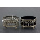 A pair of Edwardian pierced hallmarked silver salts; of oval form, each raised on four feet; one