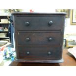 An antique miniature chest of drawers