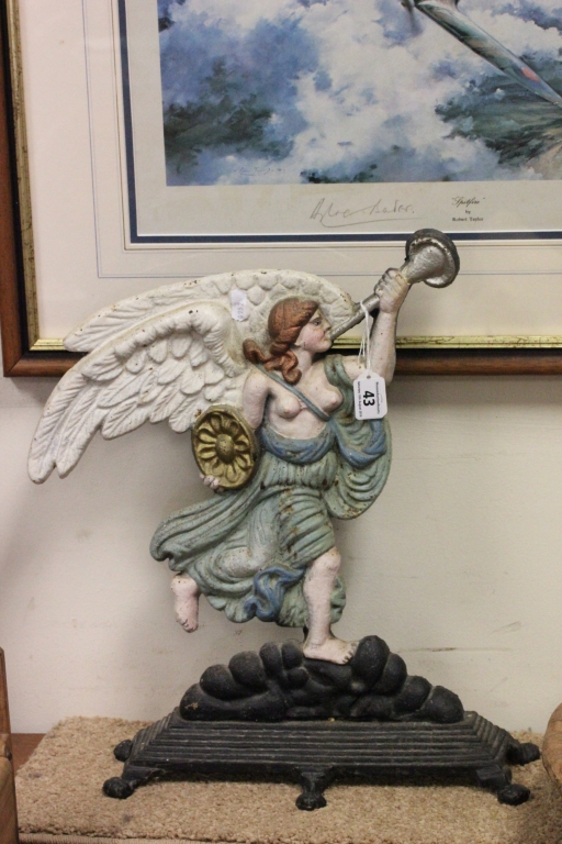 A late Victorian painted cast iron door stop; cast as a winged angel playing a horn