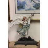 A late Victorian painted cast iron door stop; cast as a winged angel playing a horn