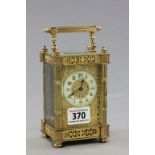 A small gilt brass carriage clock; with reeded columns; raised on four small feet; with ivorine dial