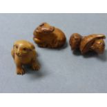 Three wooden miniature netsukes of animals including fish, calf