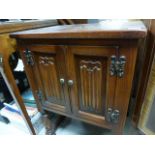 A small oak twin door cabinet; with linen fold decoration; raised on baluster supprts