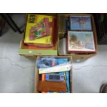 A box of various jigsaw puzzles; together with two boxes of various games and puzzles