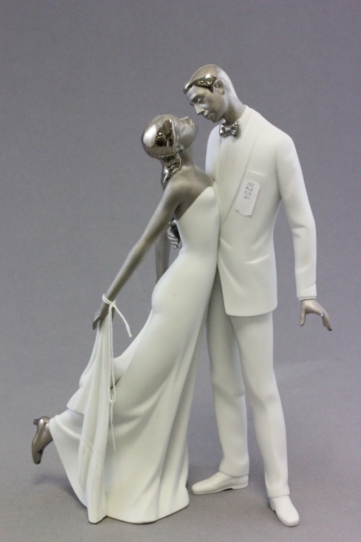 A Lladro porcelain figure of a man and woman dancing; with silver hair; bearing impressed marks to