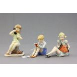 Three Goebel porcelain figures of children comprising; a boy reading a book; impressed to 216 to