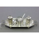 A three piece silver plate cruet set with blue glass liners; raised on four bun feet