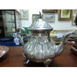 An Arabic silver teapot; bearing impressed marks to base; with bird finial; raised on four curved